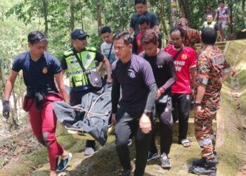 ANGGOTA pasukan penyelamat mengusung mayat Danie Asmadi yang ditemukan lemas 
di Air Terjun Belukar Bukit, Hulu Terengganu, hari ini. - UTUSAN/NOOR HAYATI MAMAT