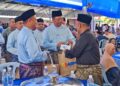 ABDUL RAHMAN Mohamad (tengah) menyampaikan sumbangan kepada salah seorang bakal jemaah haji sempena majlis jamuan Hari Raya Aidilfitri peringkat Kementerian Sumber Manusia di Lipis, Pahang. - UTUSAN/HARIS FADILAH AHMAD