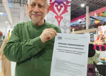 KAMARUDIN Md. Nor menunjukan borang yang perlu diisi oleh pengendali perkhidmatan bas Thailand untuk masuk ke Kelantan-UTUSAN/YATIMIN ABDULLAH.