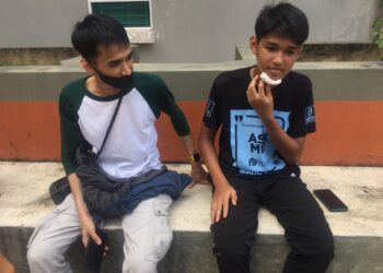 TUAN Aniq Asyraf Tuan Arzue (kiri) melihat keadaan adiknya, Tuan Muhammad Adam Asyraf yang cedera di bahagian dagu ketika ditemui di perkarangan Unit Forensik Hospital Sultan Ismail Petra, Kuala Krai, Kelantan. UTUSAN/ROSMIZAN RESDI