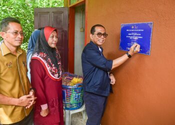 MOHAMED Khaled Nordin (kanan) menandatangani plug Penyerahan Projek Siap di Kampung Dusun Tembakau, Manir, Kuala Terengganu, hari ini. - UTUSAN/PUQTRA HAIRRY ROSLI