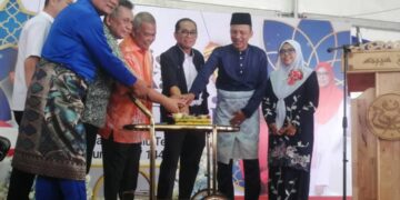 MOHAMAD Khaled Nordin (tiga dari kanan) memotong pulut kuning pada Majlis Tautan Kasih Aidilfitri UMNO Bahagian Hulu Terengganu di Kuala Berang, Hulu Terengganu, hari ini. - UTUSAN/NOOR HAYATI MAMAT