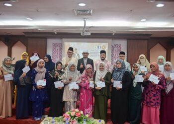 MUHAMMAD Khalil Abdul Hadi (barisan belakang, tengah) bergambar bersama penerima bantuan pada Majlis Penyampaian Bantuan Pendahuluan Nafkah Bahagian Sokongan Keluarga di Kuala Terengganu, hari ini. - UTUSAN/PUQTRA HAIRRY ROSLI