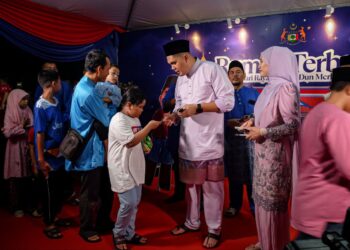 MUHAMAD AKMAL Saleh memberikan duit raya kepada kanak-kanak pada Majlis Rumah Terbuka Aidilfitri DUN Merlimau di Dataran Orang Kampung, Jasin, Melaka. - UTUSAN/SYAFEEQ AHMAD