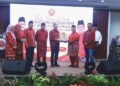 RAIS Yasin menyampaikan cenderamata kepada Asyraf Wajdi Dusuki selepas merasmikan Persidangan Berkelompok Tahunan Cawangan-cawangan UMNO Bahagian Tangga Batu di Stadium Hang Jebat, Krubong, Melaka. - UTUSAN/AMRAN MULUP