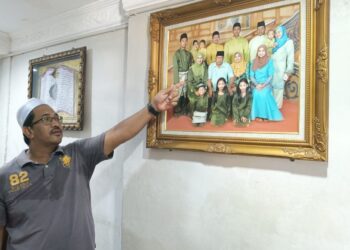 ABDUL Latif Anuar menunjukkan gambar keluarga bersama Allahyarhamah Noor Rahiza ketika ditemui di Taman Perumahan Awam ll, Jalan Pantai Murni, Yan.