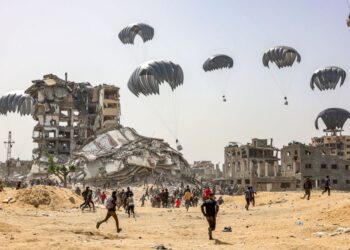 ORANG ramai bergegas mendaratkan pakej bantuan kemanusiaan yang digugurkan di utara Gaza, semalam. -AFP