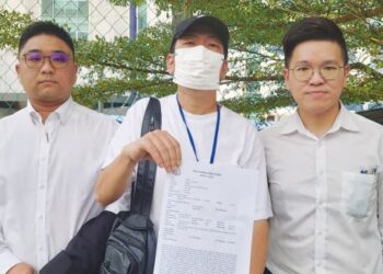 NG (tengah) menunjukkan laporan polis yang dibuat berhubung peras ugut sebanyak RM1,000 daripada dua anggota polis di BSI Johor Bahru pada Januari lalu.