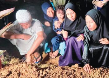 NUR Qistina Afia Mohd Azinor (tengah) membaca doa untuk arwah ibunya ketika majlis pengebumian di Tanah Perkuburan Islam Masjid Haji Nyak Gam, Kampung Ruat, Yan.