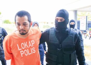 HAFIZUL Hawari yang dikawal ketat anggota Bahagian Siasatan Khas (D9) tiba di pekarangan Mahkamah Kota Bharu, Kelantan, semalam. – UTUSAN/KAMARUL BISMI KAMARUZAMAN