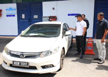 MOHD. Shuhaily Mohd. Zain (kiri) memeriksa kereta yang digunakan suspek semasa melarikan diri semasa sidang media di Ibu Pejabat Polis Kontinjen Kelantan hari ini-UTUSAN/KAMARUL BISMI KAMARUZAMAN