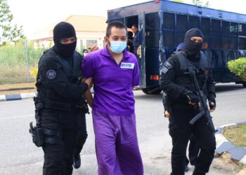 SUSPEK diiringi anggota polis hadir untuk mendapatkan perintah reman di Mahkamah Majistret Kota Bharu, Kelantan hari ini. -UTUSAN/KAMARUL BISMI KAMARUZAMAN.