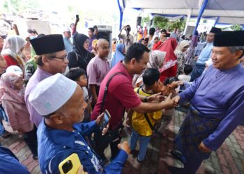 MOHAMAD Hasan (kanan) bersalaman dengan tetamu yang hadir ke majlis rumah terbuka Aidilfitri anjurannya di Kampung Tanjung, Rantau, Seremban hari ini.-UTUSAN/MOHD. SHAHJEHAN MAAMIN