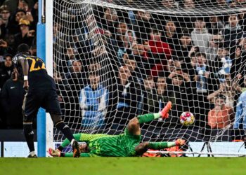 PEMAIN pertahanan Real Madrid, Antonio Rudiger melihat bola sepakan penalti diambilnya melepasi halangan penjaga gol Manchester City, Ederson dalam saingan Liga Juara-Juara di Stadium Etihad, semalam. - AFP