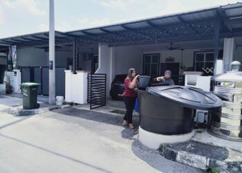 SUHAILA Saad (kiri) dan jirannya, Siti Namira Mohd. Zainol terpaksa mengangkut air daripada tong di luar rumah yang dibekalkan SADA untuk membasuh semasa ditemui di Taman Universiti Fasa 2, Semeling, Sungai Petani, Kedah.