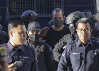 SHALOM Avitan yang diriingi anggota polis tiba di Mahkamah Sesyen Kuala Lumpur hari ini. - UTUSAN/FARIZ RUSADIO