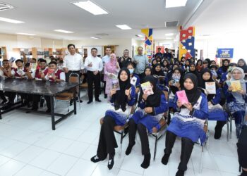 ROSLAN bersama guru dan pelajar SMK Proton City yang menerima sumbangan bahan bacaan untuk perpustakaan sekolah tersebut.