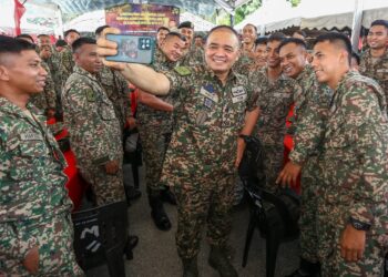 MUHAMMAD Hafizuddeain Jantan berswafoto bersama anggota tentera pada majlis sambutan Hari Raya Aidilfitri bersama anggota yang sedang bertugas di kawasan operasi di Kem Sri Banding di Gerik. - UTUSAN/MUHAMAD NAZREEN SYAH MUSTHAFA