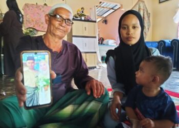 MAAROF Abdullah (kanan) bersama menantunya Nurul Alyia Che 
Mat serta cucu menunjukkan gambar anaknya  Mohamad Khairul 
Jeffry semasa ditemui di Kampung Kual To’ Uban, Pasir Mas 
semalam. – UTUSAN/ROHANA ISMAIL