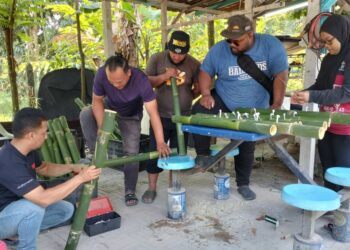 MOHD. Noor Ashraf Mohd. Nadzri (dua dari kanan) bersama adik-beradik dan ipar duai menyiapkan tempahan pelita panjut di kediaman mereka di Kampung Gunung Mesah Hulu, Gopeng. - UTUSAN