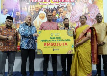 RAMANAN Ramakrishnan (tiga kiri) menyerahkan mock cek Dana Khas Pemerkasaan Wanita India kepada wakil Sahabat Usahawan India, Subathra Devi Subramaniam (dua kanan) selepas majlis pelancaran di Ibu Pejabat Amanah Ikhtiar Malaysia (AIM) di sini, kelmarin. - UTUSAN/FARIZ RUSADIO