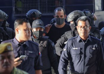 Avitan Shalom yang ditahan bersama enam pistol dan 200 butir peluru diriingi anggota polis tiba di mahkamah untuk didakwa di Mahkamah Sesyen di sini, baru-baru ini. - UTUSAN/FARIZ RUSADIO
