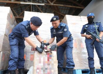 WAN Abdul Jamal Salam Wan Long (dua kiri) menunjukkan rokok yang dirampas kepada pemberita semasa sidang media di Bahagian Penguatkuasaan Kota Bharu, Kelantan hari ini-UTUSAN/KAMARUL BISMI KAMARUZAMAN