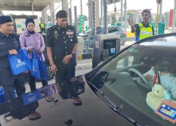 MOHAMED Usuf Jan Mohamad (tiga dari kiri) ketika mengagihkan 'goodies bag' kepada pengguna jalan raya yang melalui Plaza Tol Juru arah utara, berhampiran Bukit Mertajam, Pulau Pinang hari ini.