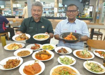SHARIL Nizal (kiri) menunjukkan antara menu di restoran Zainal's Place di Johor Bahru yang menjadi tarikan pelancong luar khususnya dari Singapura.