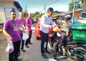 AIMAN Yusri (kiri) agihkan air percuma kepada pengguna penduduk Kampung Pasir Pekan, Tumpat, Kelantan-UTUSAN/ROHANA ISMAIL.