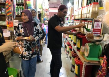 MOHD. Firdaus Sultan Kabeer (kanan) menimbang rempah untuk dijual kepada pelanggan di Pasar Siti Khadijah, Kota Bharu, Kelantan-UTUSAN/ROSLIZA MOHAMED.