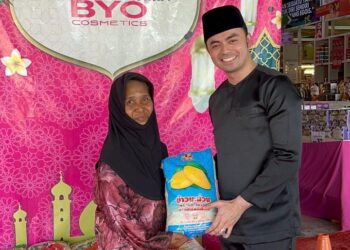 MOHD.  Fazrin A. Zuhari (kanan) menyampaikan sumbangan beras kepada penerima pada program kongsi rezeki di Jelawat Bachok, Kelantan.