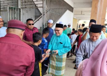 MOHD. Amar Nik Abdullah (dua dari kanan) mengagihkan sampul raya kepada kanak-kanak yang hadir pada Jamuan Hari Raya Aidilfitri Pas Kawasan Pengkalan Chepa di Pengkalan Chepa, Kota Bharu, Kelantan hari ini. UTUSAN/MUSTAQIM MOHAMED