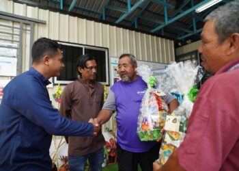 NELAYAN Unit Permatang Tepi Laut, Zulkipli Bakar (dua dari kanan) menerima hamper perayaan daripada pegawai kanan informasi PPSN, Mohammad Qhidir Subri (kiri) di PPSN Permatang Damar Laut, di Pulau Pinang.