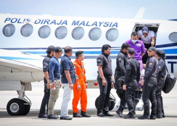 HAFIZUL Hawari (berbaju ungu) tiba di Pangkalan Pasukan Gerakan Udara (PGU)  Subang, Selangor, dengan kawalan ketat beberapa anggota polis. - UTUSAN/ SADDAM YUSOFF