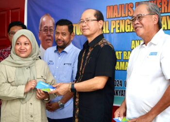 WILFRED Madius Tangau (tengah) menyampaikan bantuan awal Yayasan Bank Rakyat (YBR) kepada pelajar daripada golongan asnaf dan B40 yang terlibat.