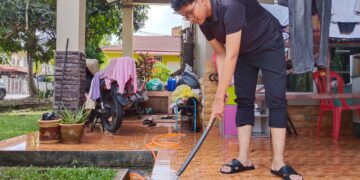 MUHAMMAD FAIZUL AMIR Hisahammuddin membersihkan lantai rumahnya yang berlumpur di Taman Masjid Tanah Ria, Alor Gajah, Melaka. - UTUSAN/MUHAMMAD SHAHIZAM TAZALI