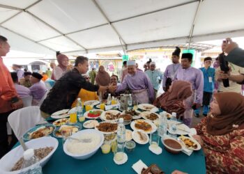 TUAN Ibrahim Tuan Man (kanan) meluangkan masa untuk menyantuni hadirin di Majlis Rumah Terbuka Aidilfitri Pas Kelantan di Dataran Warisan Stadium Sultan Muhammad IV, Kota Bharu, Kelantan hari ini. UTUSAN/MUSTAQIM MOHAMED