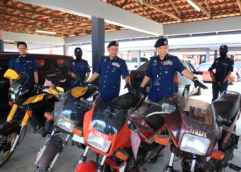 WAN Jamal Abdul Salam Wan Long (kanan) bersama pegawai memeriksa model motosikal jenis Yamaha RXZ yang diseludup dari Thailand semasa sidang media di Unit Operasi Penguatkuasaan JKDM, Kota Bharu, Kelantan-UTUSAN/KAMARUL BISMI KAMARUZMAN.