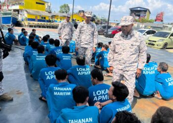 ERWAN Shah Soahdi (berdiri, kanan) semasa melakukan pemeriksaan ke atas nelayan asing Vietnam yang berjaya ditahan di Pejabat Maritim Kelantan di Tok Bali, Pasir Puteh, Kelantan hari ini. UTUSAN/TOREK SULONG