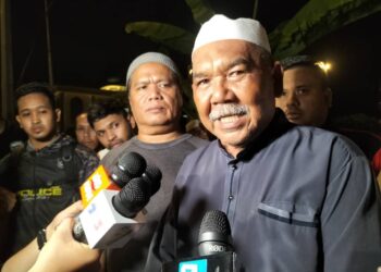 RAMLI Abd. Hamid (kanan) ketika ditemui pemberita selepas majlis pengebumian anaknya, Komander Muhammad Firdaus Ramli di tanah perkuburan Islam Masjid Jamek Sungai Nibong Besar, George Town, Pulau Pinang