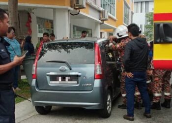 ANGGOTA bomba berusaha menyelamatkan dua beradik masing-masing berusia empat serta enam tahun yang terkunci dalam sebuah kereta Perodua Viva di hadapan sebuah premis perniagaan di PD Waterfront PD, Port Dickson petang semalam./GAMBAR/IHSAN BOMBA
