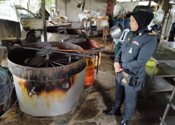 SEORANG pegawai KPDN Kuala Pilah memeriksa sebuah kilang memproses tauhu goreng di Bahau, Jempol semalam selepas disyaki menggunakan logo halal yang tidak iktiraf oleh Jakim-GAMBAR/IHSAN KPDN.