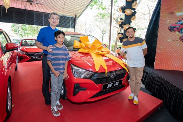 Tan Sri Ir (Dr.) Lim Hock San bersama salah seorang pemilik rumah bertuah yang memenangi Perodua Axia di majlis penyampaian hadiah.
