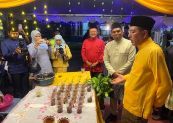 MUHAMAD Zaki (kanan) memberi duit raya kepada kanak-kanak di Dewan Tanjung, Ibu Pejabat Polis Daerah (IPD) Gua Musang, Kelantan-AIMUNI TUAN LAH.