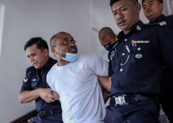 TERTUDUH diiring anggota polis selepas mengaku bersalah di Mahkamah Tinggi, Melaka atas kesalahan memiliki dadah jenis kanabis. - UTUSAN/SYAFEEQ AHMAD