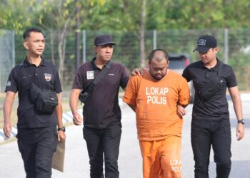 TERTUDUH diiringi polis semasa menghadiri prosiding pendakwaan di Mahkamah Sesyen Kota Bharu, Kelantan hari ini-UTUSAN/KAMARUL BISMI KAMARUZAMAN.