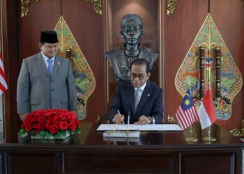 MOHAMED Khaled Nordin menandatangani buku lawatan sempena 
kunjungan beliau ke Kementerian Pertahanan Indonesia di Jakarta 
sambil disaksikan oleh Prabowo Subianto.