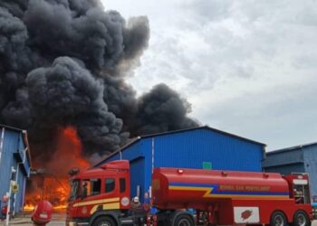 PASUKAN bomba memadamkan kebakaran kilang di Cenviro Sdn. Bhd. (Pusat Kualiti Alam), Ladang Tanah Merah, Bukit Pelanduk, Port Dickson petang semalam-GAMBAR/IHSAN BOMBA.