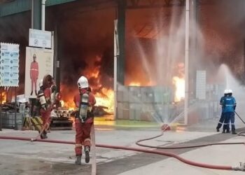 ANGGOTA bomba sedang memadamkan kebakaran tempat logistik simpanan sisa bahan kimia berjadual di Cenviro Sdn. Bhd (Kualiti Alam), Ladang Tanah Merah Bukit Pelanduk, Port Dickson petang tadi-GAMBAR/IHSAN BOMBA.
